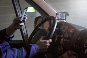 close up of driver using phone while driving